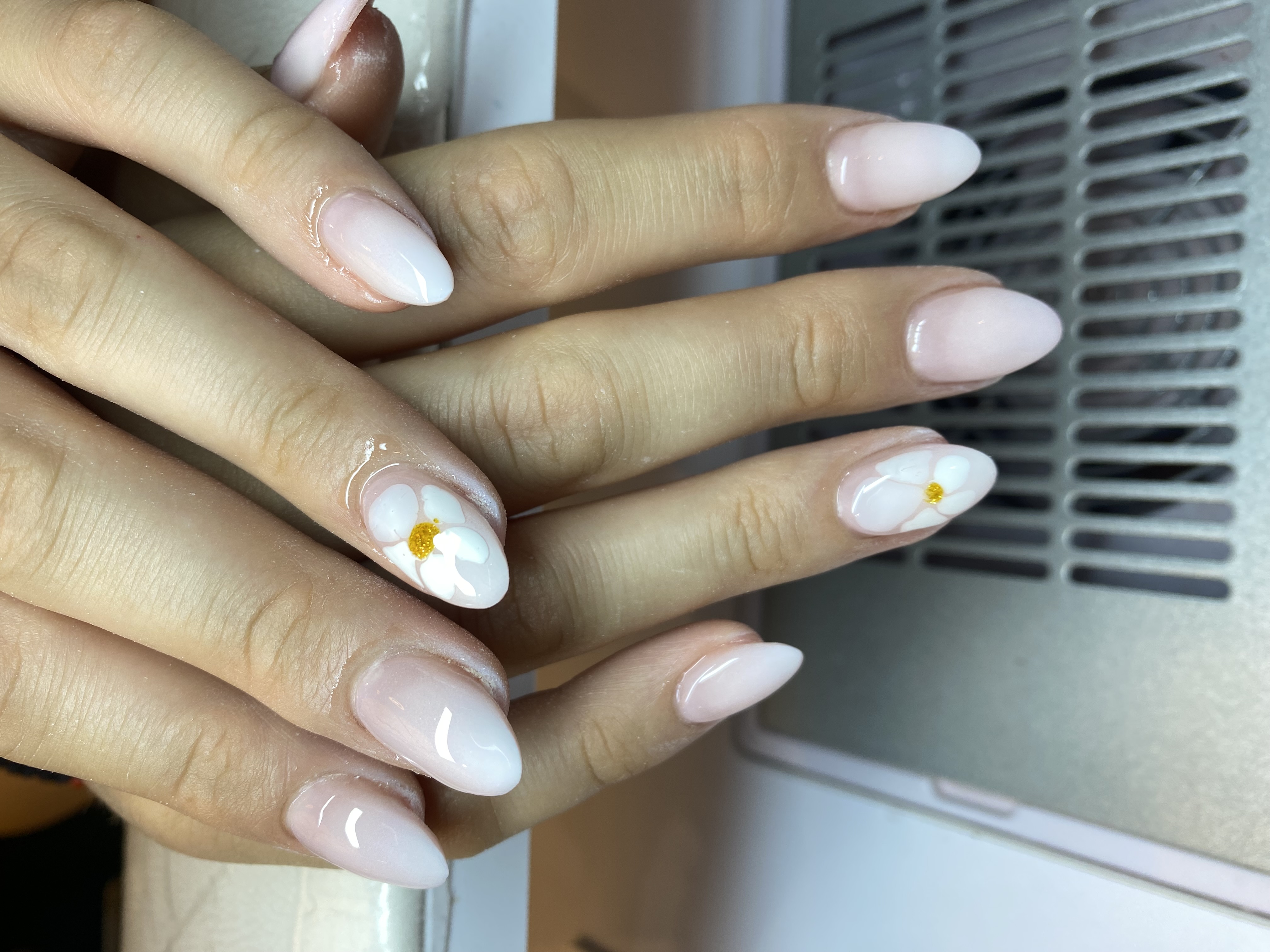 Manucure nude blanche avec fleurs réalisée chez Glam Nails Studio